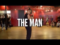 a man standing on top of a hard wood floor in front of a red wall