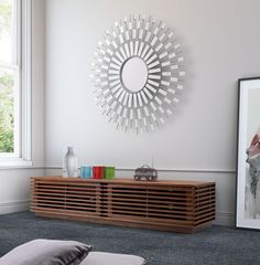 a living room with a large mirror on the wall and pillows in front of it