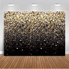 black and gold glitter wall mural in an empty room with wood flooring, two lights on