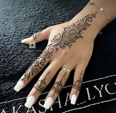 a woman's hand with henna tattoos on it