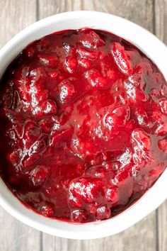 a white bowl filled with cranberry sauce on top of a wooden table