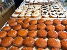 many different kinds of doughnuts on display in a store