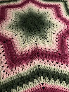 a crocheted blanket is laying on the floor