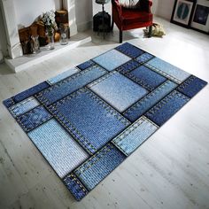 a blue area rug on the floor in front of a fire place with a red chair