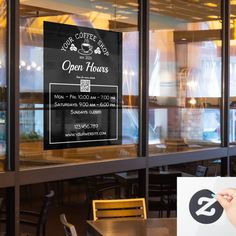 an open house sign in the window of a restaurant with chairs and tables behind it