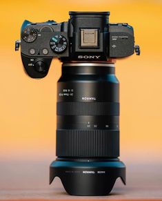 a sony camera sitting on top of a large black object with the lens attached to it's body