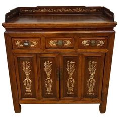 an ornate wooden cabinet with gold designs on the doors and drawers, sideboard or cupboard