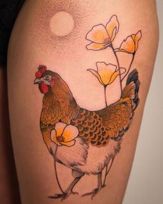 a chicken and flower tattoo on the thigh, with an orange sun in the background