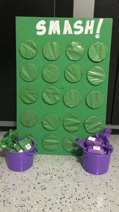 two purple buckets are sitting in front of a green sign that says smash on it