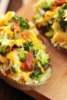 baked potatoes with broccoli, bacon and cheese are on a wooden cutting board