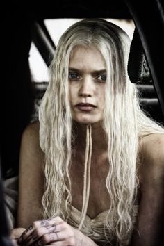 a woman with long white hair sitting in a car