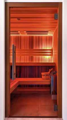 the inside of a sauna is lit up with red lights and wood paneling