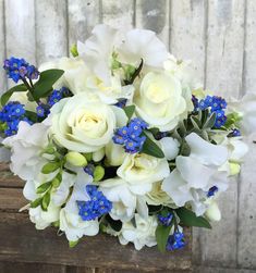 a bouquet of white roses and blue flowers