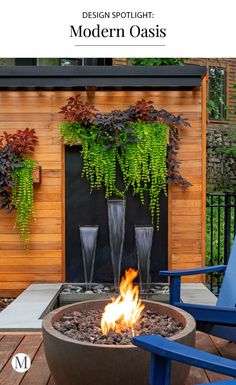 a fire pit sitting on top of a wooden deck next to two blue lawn chairs