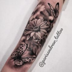 a black and white photo of a sunflower with butterflies on it's arm