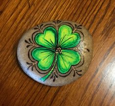 a painted rock with a four leaf clover on it