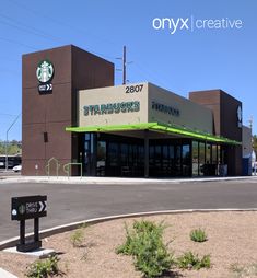 the starbucks is located on the side of the road in front of an empty parking lot