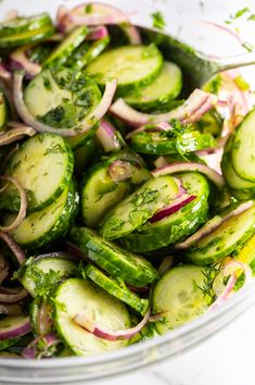 a bowl filled with cucumbers and onions