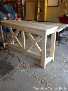 a wooden table sitting inside of a garage