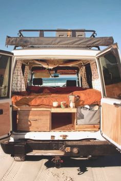 the back end of a van with an open trunk and bed in it's cargo area