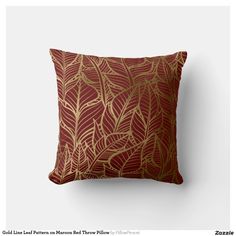 a red and gold pillow with leaves on it