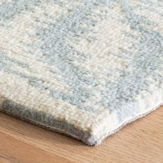 a close up of a rug on a wooden floor with wood floors and furniture in the background