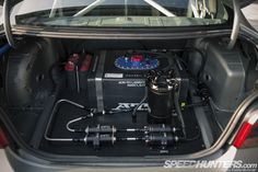 the back end of a car with its trunk open and various equipment in it's compartment