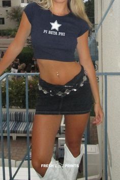 a woman in cowboy boots is posing for the camera with her shirt open and jeans on