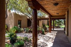 an outdoor covered patio with potted plants and trees