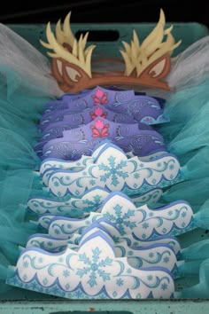 frozen princess cookies are lined up in a row on a table with blue tulle