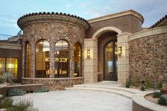 a large house with stone walls and arched windows