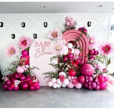 there is a pink and white backdrop with flowers on the floor next to a grave