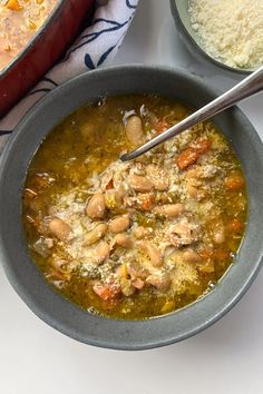 a bowl filled with soup next to another bowl full of rice and other food items