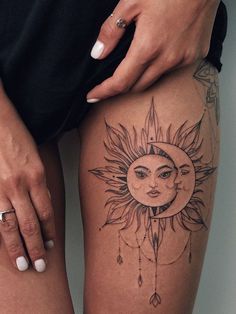 a woman's legs with sun and moon tattoos on them, while holding a pencil in her left hand