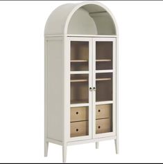 a white cabinet with two drawers and an arched glass door