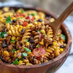 a wooden bowl filled with pasta salad