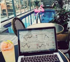 an open laptop computer sitting on top of a table next to a glass filled with orange juice