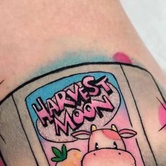 a cartoon cow with the words harvest moon on it's chest is shown in this tattoo design