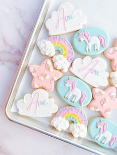 cookies decorated with unicorns and clouds on a tray