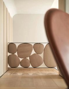 a wooden chair sitting on top of a hard wood floor next to a white wall