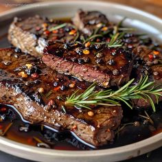 two steaks with rosemary garnish in a bowl