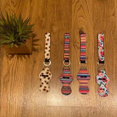 four different types of dog collars on a wooden table next to a potted plant