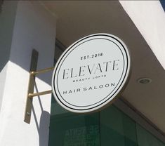 the sign for elevate beauty lofts hangs from the side of the building