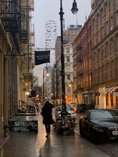 a person walking down a street in the rain