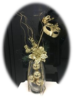 a masquerade mask and some ornaments in a vase