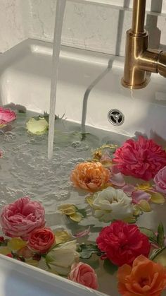 water flowing from a faucet into a sink with colorful flowers on the bottom