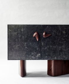 a black marble cabinet with two wooden handles