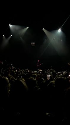 a man standing on top of a stage in front of a crowd at a concert