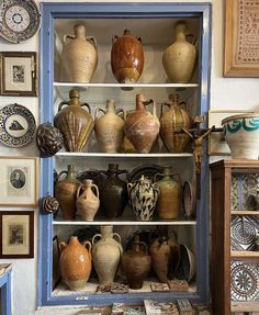 a cabinet filled with lots of vases on top of shelves