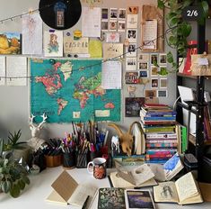 a desk with many books and plants on it